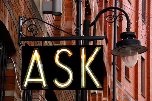 A sign with a lamp with ask on it