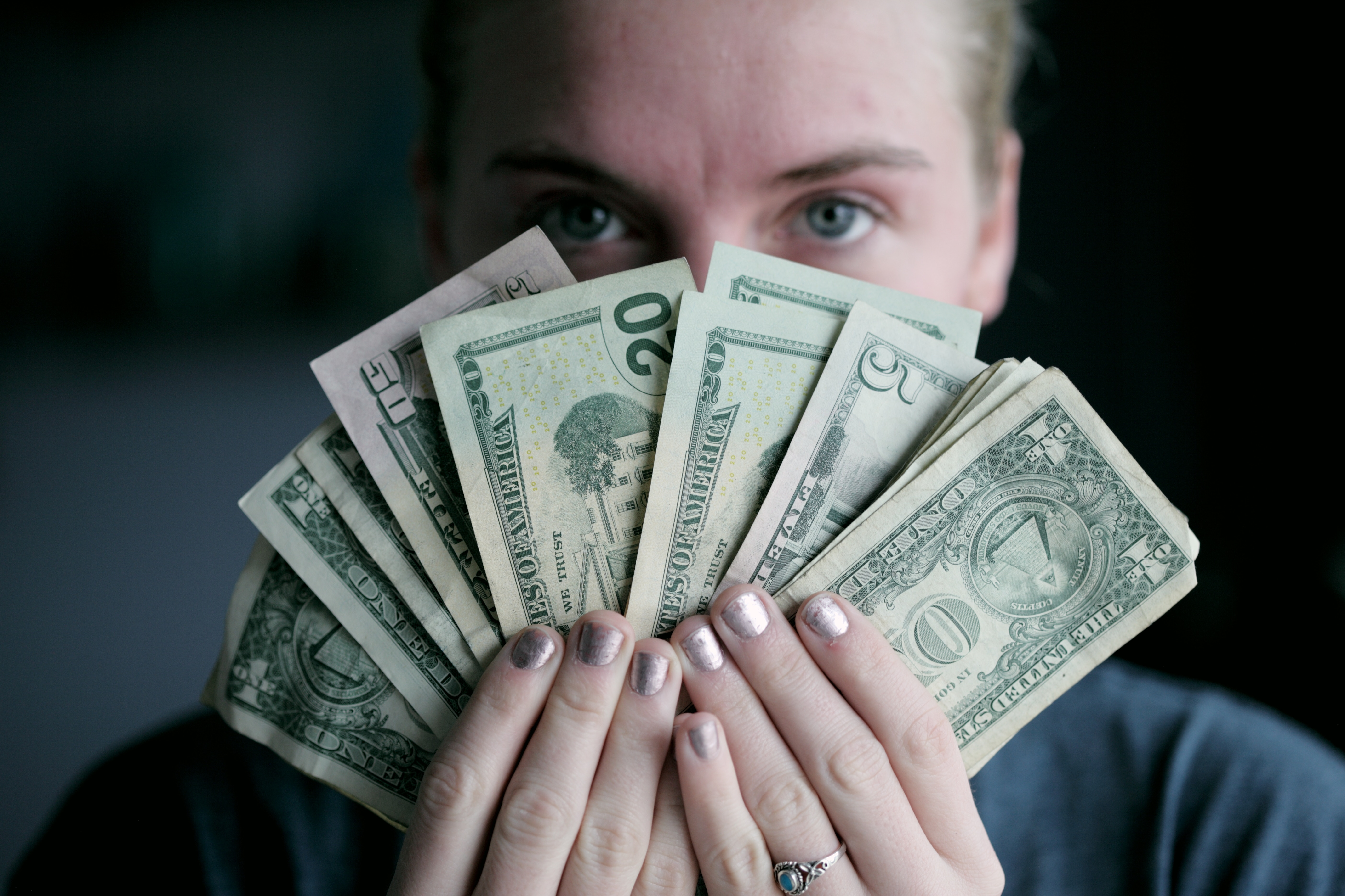 a woman holding a handful of money